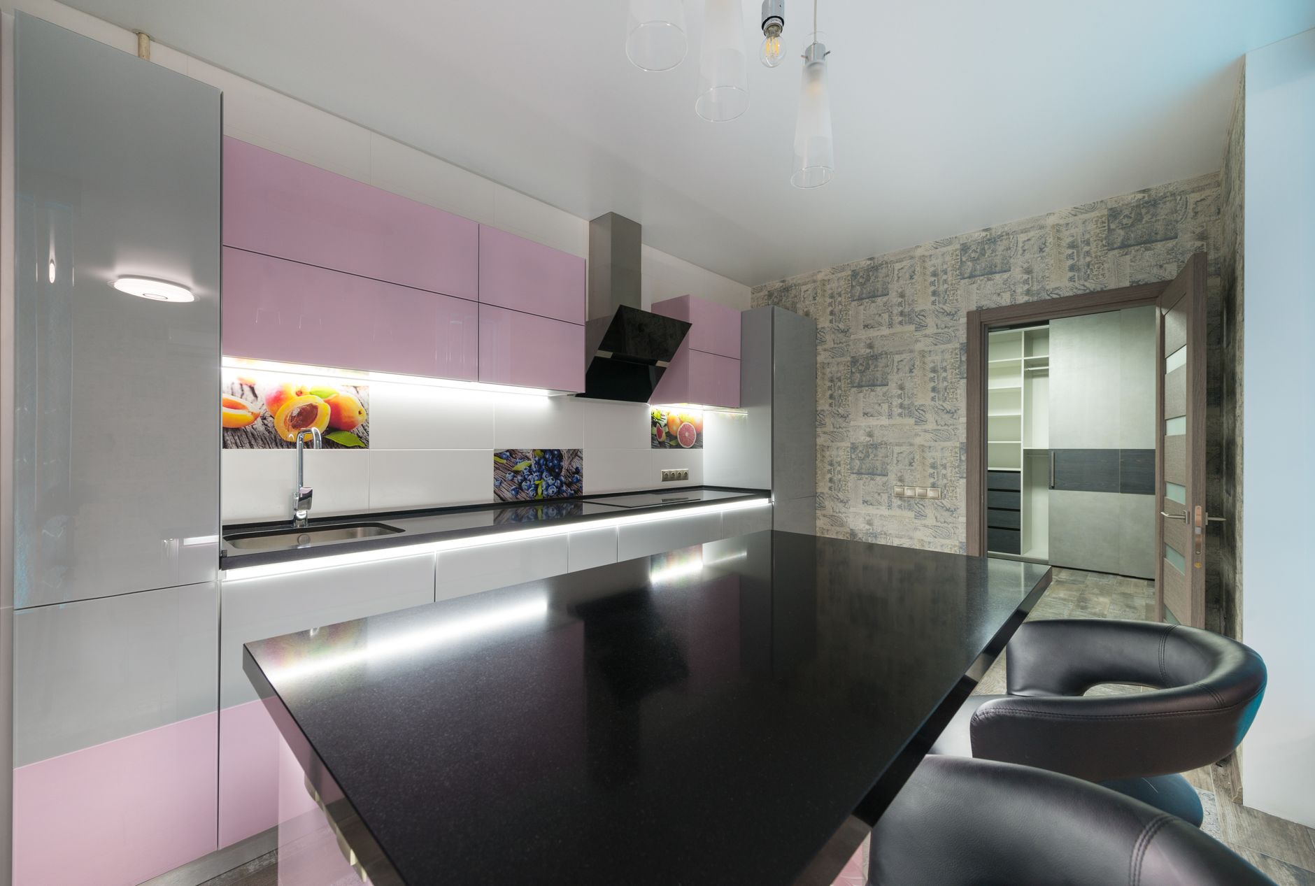 Black table with chairs placed near colorful cupboards and modern kitchenware in stylish kitchen with opened in Austin, TX